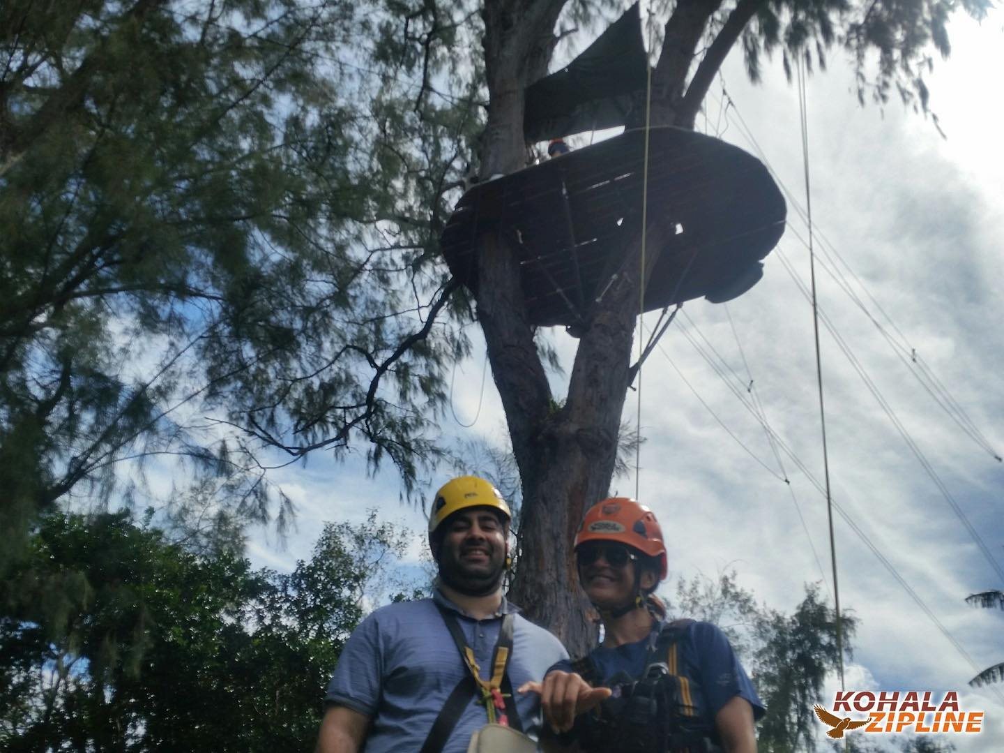 Noah wearing a helmet and safety harness with a zipline guide in Hawaii